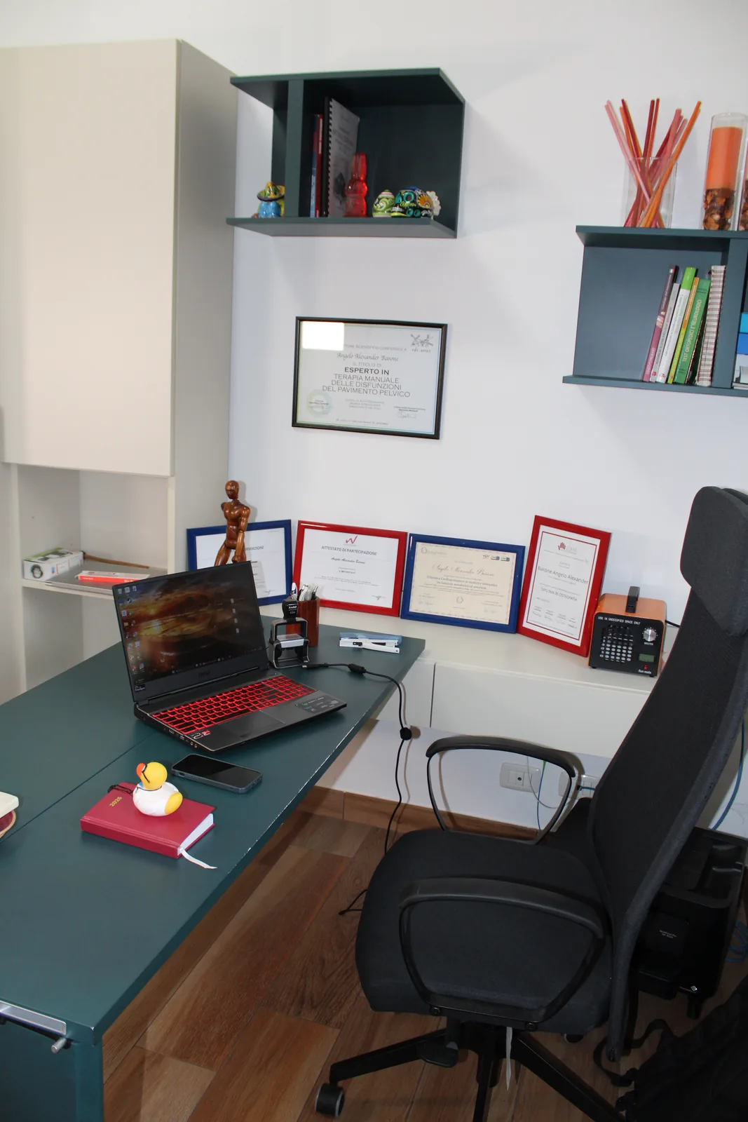 Scrivania dello studio con diplomi e attestati di Angelo Barone, osteopata D.O.